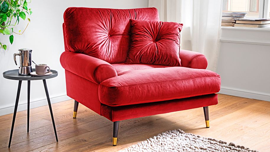 Roter Sessel aus Samt in einem Wohnzimmer Roter Sessel aus Samt in einem Wohnzimmer