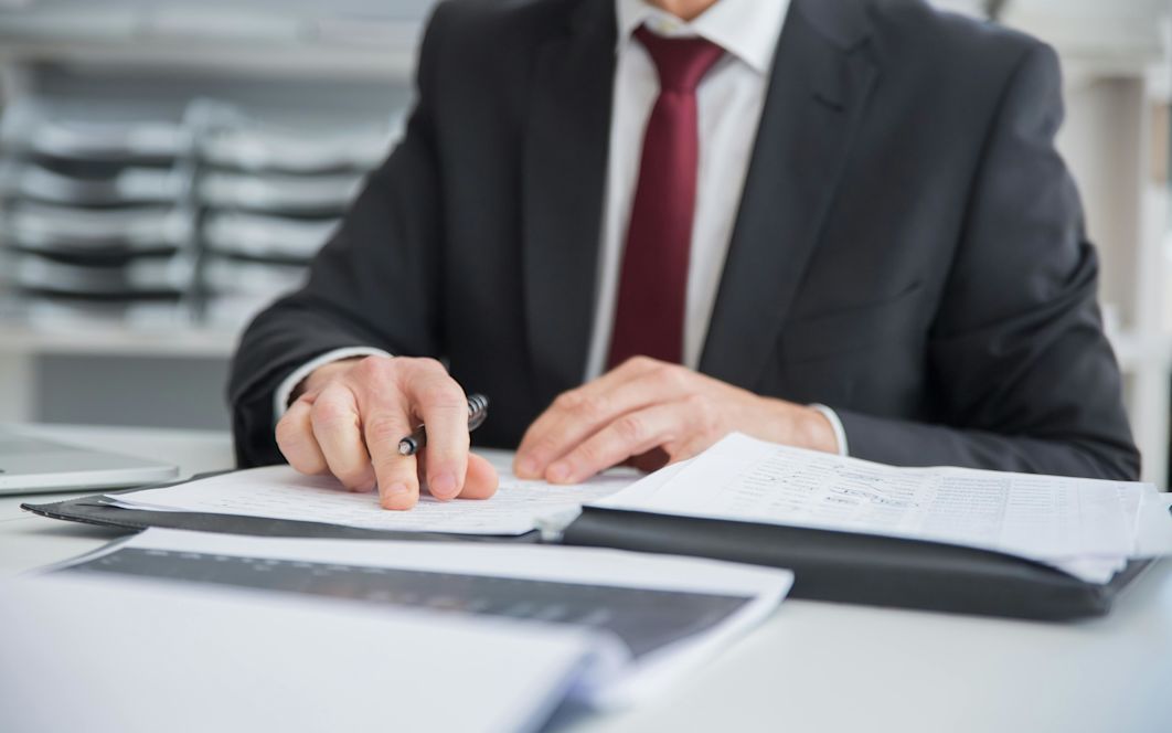 Menschliche Hand mit Stift, die einen Vertrag unterschreibt